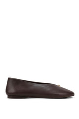 A pair of deep burgundy velvet Mary Jane flats with a small gold-tone circular buckle, shown in a side profile against a light gray background.