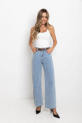 Woman wearing a white top and light blue jeans on a white background