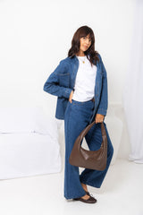 River wide-leg denim jeans in mid blue, high-waisted straight-leg jeans styled with a denim jacket, white tee, and brown shoulder bag