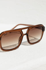 Brown sunglasses with a gradient lens on a white background