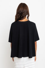 Person wearing a black top with a white background
