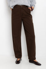 Person wearing brown pants and a gray sweater on a white background