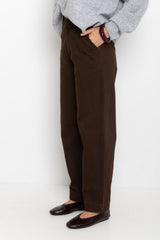 Person wearing brown pants and a gray sweater against a white background