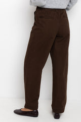 Brown pants worn by a person on a white background