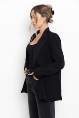 Person wearing a black blazer and pants on a white background