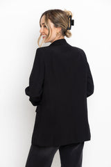 Woman wearing a black blazer against a white background