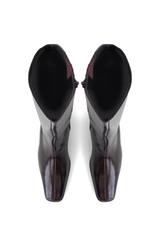 A pair of glossy dark brown leather boots with a pointed toe and high black lining, shown from a top-down view on a white background.
