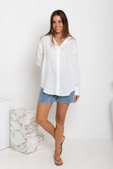 Woman wearing a white shirt and denim shorts on a white background