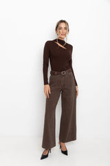 Woman wearing a brown turtleneck and wide-leg pants on a white background