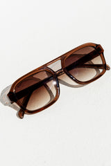 Brown sunglasses on a light gray background