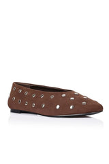 A brown suede flat shoe with silver metal studs, shown from a side profile on a white background.