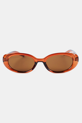 Oval sunglasses with a translucent amber-orange frame and brown tinted lenses, shown against a light gray background.