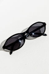 Black sunglasses on a white surface
