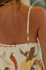 Person wearing a sleeveless dress with leaf pattern, back view