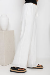 Willow straight-leg linen pants in white, drawstring waist trousers styled with a black tank top and platform flip-flop sandals